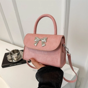 Pink PU leather crossbody bag with silver metal bow detail and top handle strap