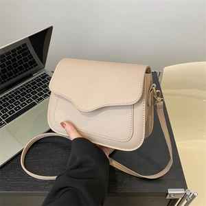 Minimalist beige leather shoulder bag for women with gold hardware and curved flap