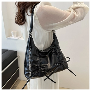 Detail of black PU leather bag with bows, silver chain, and Fashion & Bags text logo