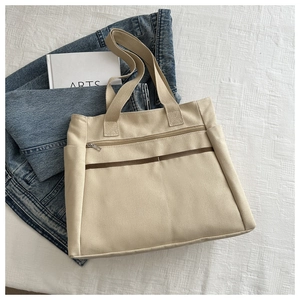 Vista piatta della borsa tote grande in tela beige con strisce marroni e tasca zip