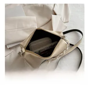 Detailed interior of a beige crossbody bag showing its large storage capacity for essentials