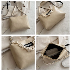 Detail view of beige PU shoulder bag with bold acrylic chain and spacious interior layout