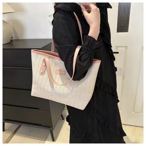 Détail du sac cabas tissé en V avec bandoulières en cuir rose et étiquette