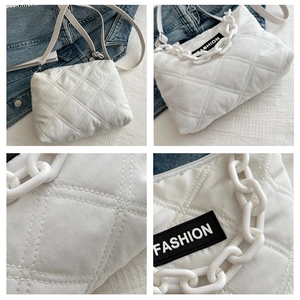 Dettaglio della borsa trapuntata bianca con catena in plastica e toppa logo moda