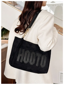 Détail du grand sac cabas en daim noir avec lettrage HOOTO et chaîne dorée