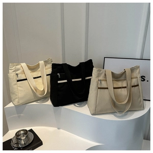 Tre borse tote in tela nei colori bianco, nero e kaki con design multi-tasca funzionale