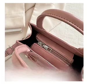 Vista dettagliata dell'interno della borsa in pelle rosa con cerniera e ciondolo a perla