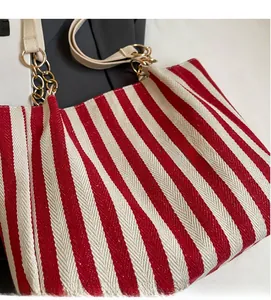 Detail der rot-weiß gestreiften Canvas-Tasche mit Leder- und Goldkettenriemen
