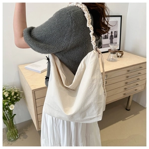 Off-white large canvas tote bag with ruched shoulder strap in a minimalist setting