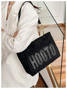 Détail du sac cabas HOOTO avec texture suédée noire et bandoulière en chaîne dorée