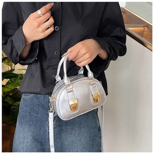 Detail of silver metallic mini Boston bag with dual handles and golden buckles