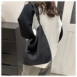 Detailed back view of a black pleated strap hobo bag made of soft nylon material