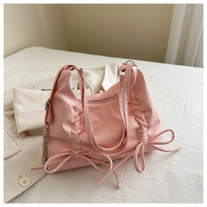 Detail of pink bow backpack with metallic chain and lightweight glossy fabric