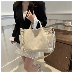 Detail of beige corduroy tote bag showing ribbed texture and side pocket for daily commuting
