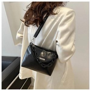 Détail du sac bandoulière noir avec chaîne épaisse et étiquette Fashion sur cuir lisse