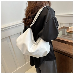 Detailed side view of white soft leather tote bag with stylish pleated texture and straps