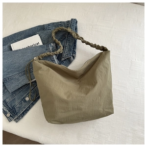 Close-up of olive green hobo bag with cloud-like ruched strap and textured fabric