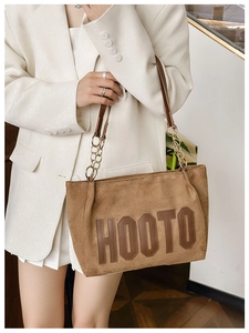 Détail du sac cabas en daim marron avec logo HOOTO et bandoulière en chaîne et cuir