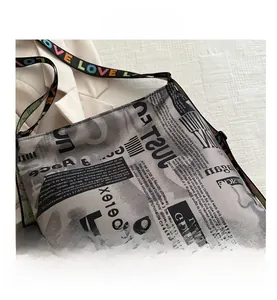 Détail du sac en toile avec imprimé journal et bandoulière brodée LOVE colorée