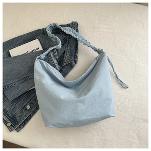 Top view of light blue dumpling tote bag with a unique scrunchie shoulder strap detail