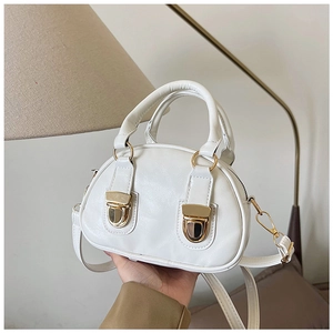 Close-up of white Boston handbag with gold double-push locks and oil-wax leather texture