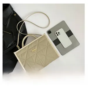 Detailed comparison of beige quilted tote bag capacity with tablet and smartphone