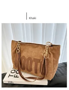 Détail du sac à bandoulière en daim kaki avec chaîne en métal sur un livre Tom Ford