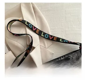 Détail d'une large bandoulière tissée avec lettrage LOVE coloré sur un sac fourre-tout