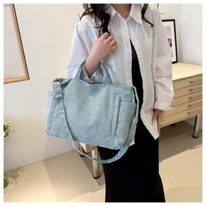 Close-up of light blue corduroy tote bag showing textured vertical ribs and shoulder strap