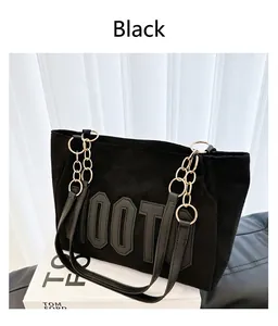 Détail du sac cabas en daim noir avec lettres OOT embossées et chaîne dorée