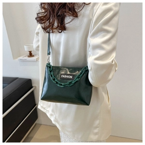 Détail du sac rétro vert foncé avec chaîne en acrylique et étiquette de mode