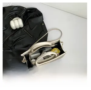 Top view of spacious cream tote bag filled with daily items like a phone and umbrella