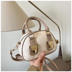Close-up of retro Boston bag showing contrast stitching and gold metal buckles