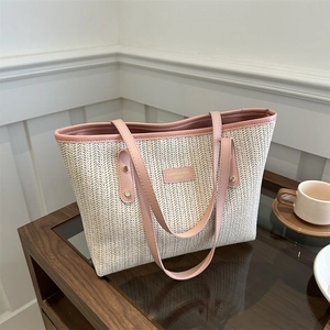Grand sac cabas en paille crème avec anses en cuir rose et plaque logo en métal