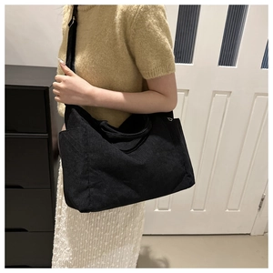 Model wearing a black corduroy tote bag showing casual style and large capacity detail