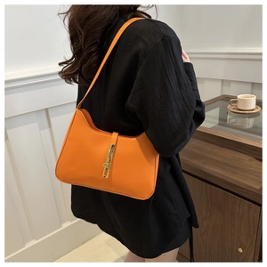 Detailed view of bright orange hobo shoulder bag featuring a stylish gold metal buckle closure