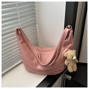 Detail of dusty pink crescent bag with textured faux leather and plush bear charm