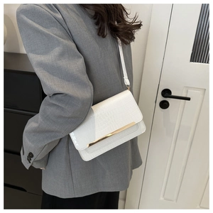 Detailed view of white crocodile pattern envelope crossbody bag with gold metal trim
