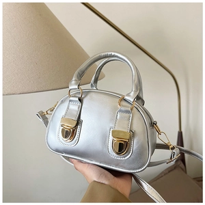 Detail of silver oil wax leather Boston bag featuring vintage gold buckles and hardware