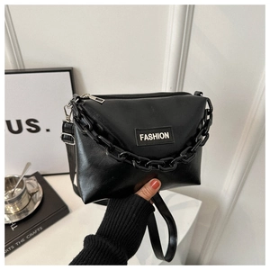 Close-up of black PU leather handbag featuring chunky chain link and fashion label detail