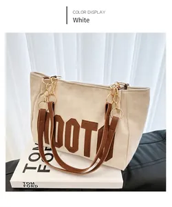 Gros plan détaillé du sac cabas beige en velours avec anses en cuir brun et chaîne dorée