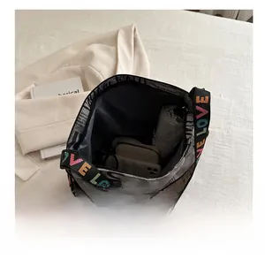 Vue intérieure du sac à motif journal montrant la grande capacité pour parapluie et mobile