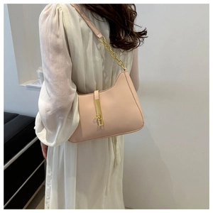 Detail of light pink shoulder bag with gold chain strap and metallic buckle