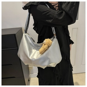 Silver metallic crescent hobo bag featuring a cute brown plush bear charm detail