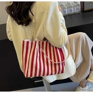 Detail der rot-weiß gestreiften Canvas-Tasche mit Goldkette und cremefarbenem Gurt