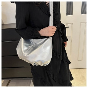 Detail of silver metallic crescent bag with pleated design and Fashion & Bag logo tag