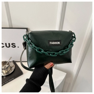 Detailed view of dark green PU leather bag featuring bold chain and FASHION label