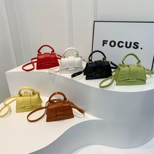 Vintage crocodile pattern mini handbags in six vibrant colors displayed on a podium