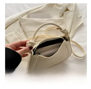 Interior view of cream crescent bag showing storage space for phone and essentials