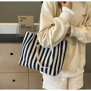 Detailaufnahme der gestreiften Canvas-Einkaufstasche mit Kette und Ledergriff
